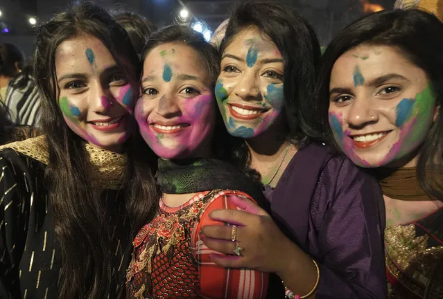 Girls from Pakistani Hindu community smear their faces with colors to to celebrate the Holi Festival, in Karachi, Pakistan, Monday, March 6, 2023. Holi Festival marks the beginning of spring and the triumph of good over evil. (Photo by Fareed Khan/AP Photo)