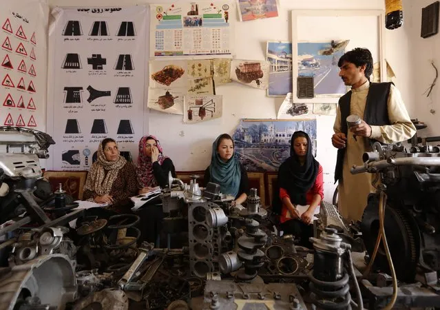 An instructor (R) teaches women about a car's mechanics during a technical lesson at a driving school in Kabul August 11, 2014. (Photo by Mohammad Ismail/Reuters)