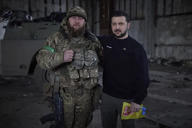 In this photo provided by the Ukrainian Presidential Press Office, Ukrainian president Volodymyr Zelenskyy and a soldier pose for a photo after an awarding ceremony at a position near Bakhmut, Donetsk region, Ukraine, Wednesday, March 22, 2023. (Photo by Ukrainian Presidential Press Office via AP Photo)