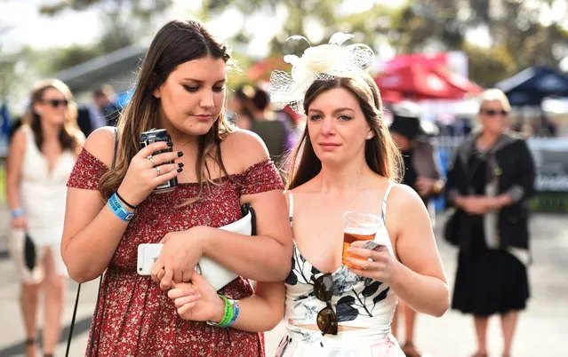 Race goers nurse their drinks after the Geelong Cup on Geelong Cup day at Geelong Racecourse in Melbourne, Australia, 19 October 2016. (Photo by Tracey Nearmy/EPA)