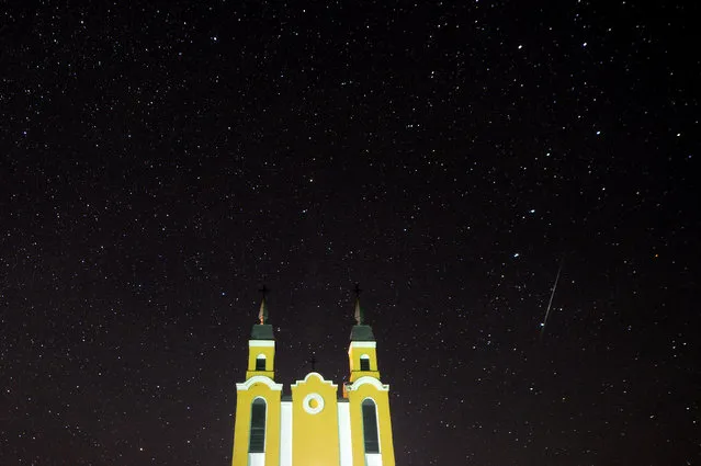 A meteor streaks across the sky behind a Catholic church during the annual Geminid meteor shower in the village of Krevo, some 100 km northwest of Minsk, on December 14, 2017. (Photo by Sergei Gapon/AFP Photo)