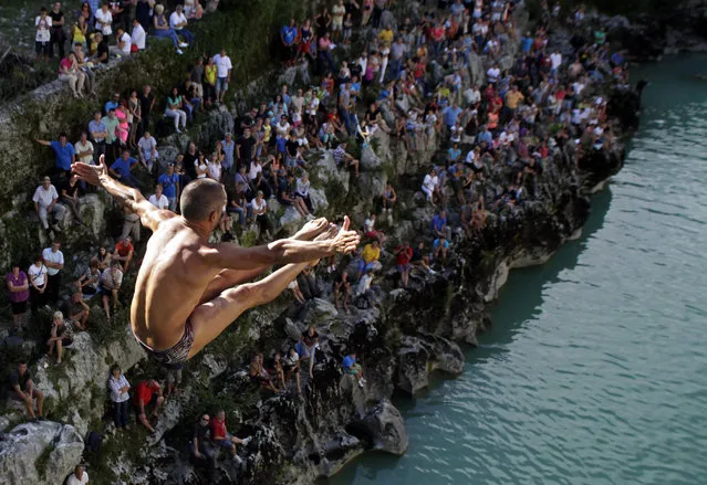 A competitor leaps up the air during a bridge jumping competition in Kanal ob Soci August 17, 2014. (Photo by Srdjan Zivulovic/Reuters)