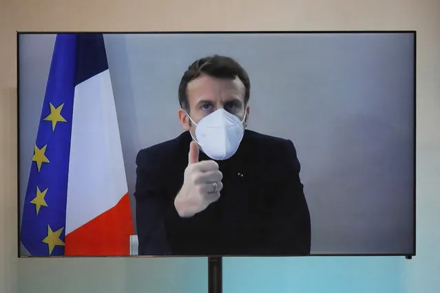 French President Emmanuel Macron is seen on a screen as he attends by video conference a round table for the National Humanitarian Conference (NHC), taken at the Foreign Ministry in Paris,Thursday, December 17, 2020. French President Emmanuel Macron tested positive for COVID-19 Thursday following a week in which he met with numerous European leaders. The French and Spanish prime ministers and EU Council president were among many top officials self-isolating because they had recent contact with him. (Photo by Charles Platiau/Pool via AP Photo)
