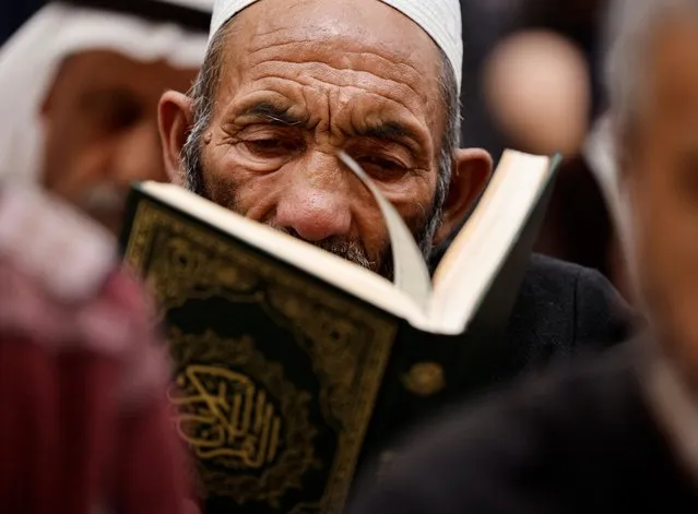 A Shi'ite Muslim man reads the Koran during the holy month of Ramadan at Imam Ali Shrine in the holy city of Najaf,Iraq on April 10, 2023. (Photo by Thaier Al-Sudani/Reuters)