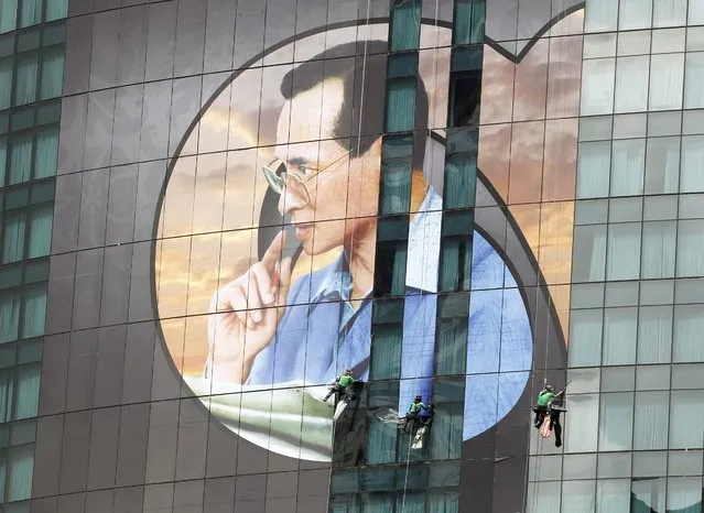 Thai workers install a giant portrait of the late Thai King Bhumibol Adulyadej to honor the king at a high-rise building in Bangkok, Thailand, 31 October 2016. Thailand's gross domestic product (GDP) is forecasted to grow by 3.3 per cent in 2016 and 3.4 per cent in 2017 boosted by accelerated investment into big infrastructure projects by the government, increasing of tourist arrival while the public consumption has sluggish currently and expected to raise after the nationwide official mourning period for the late Thai King Bhumibol Adulyadej. (Photo by Rungroj Yongrit/EPA)