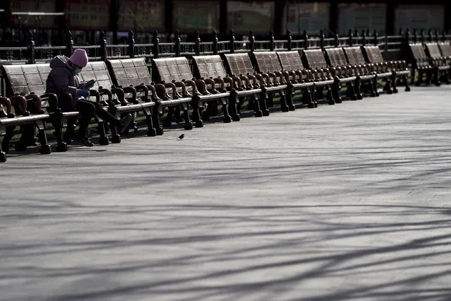 A woman wearing a face mask to help curb the spread of the coronavirus takes a rest on the bench at the Forbidden City in Beijing, Sunday, January 10, 2021. More than 360 people have tested positive in a growing COVID-19 outbreak south of Beijing in neighboring Hebei province. (Photo by Andy Wong/AP Photo)