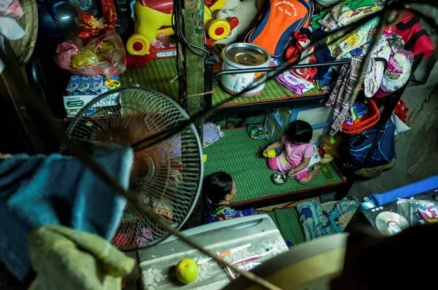 A woman and a child are seen inside one of their relative' s two- square- metre home in Ho Chi Minh City on May 2, 2018. (Photo by Thanh Nguyen/AFP Photo)