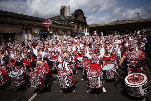 Batala Mundo bands pass Westbourne Park Underground station as they take part in the main parade of the Notting Hill Carnival in west London on August 26, 2024. Tens of thousands of revellers turned out to enjoy the final day of this year’s Notting Hill carnival, flooding the streets of west London with colour, dancing and music. (Photo by Henry Nicholls/AFP Photo)