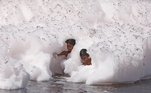 Boys play in the foam covering the polluted water of the river Yamuna in New Delhi, India March 25, 2018. (Photo by Adnan Abidi/Reuters)