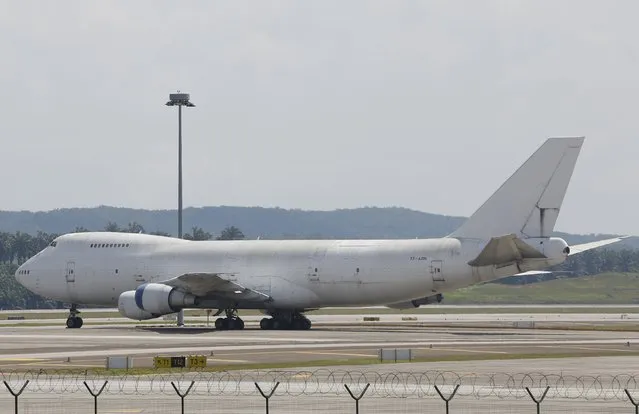One of three abandoned Boeing 747-200F planes is seen parked on the tarmac at Kuala Lumpur International Airport in Sepang, Malaysia, December 10, 2015. Malaysia's airport operator took out newspaper adverts to find the owners of three Boeing 747  that have been sitting idle for more than a year. (Photo by Olivia Harris/Reuters)