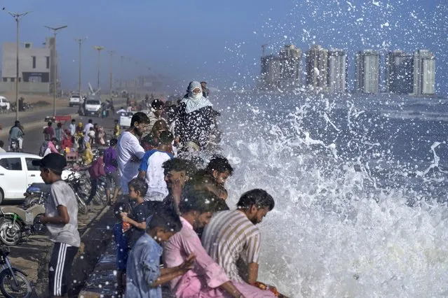 People enjoy high tide waves on the Arabian Sea, in Karachi, Pakistan, Sunday, June 11, 2023. Pakistani Prime Minister Shehbaz Sharif ordered officials to put in place emergency measures in advance of the approaching Cyclone Biparjoy in the Arabian Sea. The “severe and intense” cyclone with wind speeds of 150 kilometers per hour (93 miles per hour) was on a course toward the country's south, Pakistan's disaster management agency said. (Photo by Fareed Khan/AP Photo)