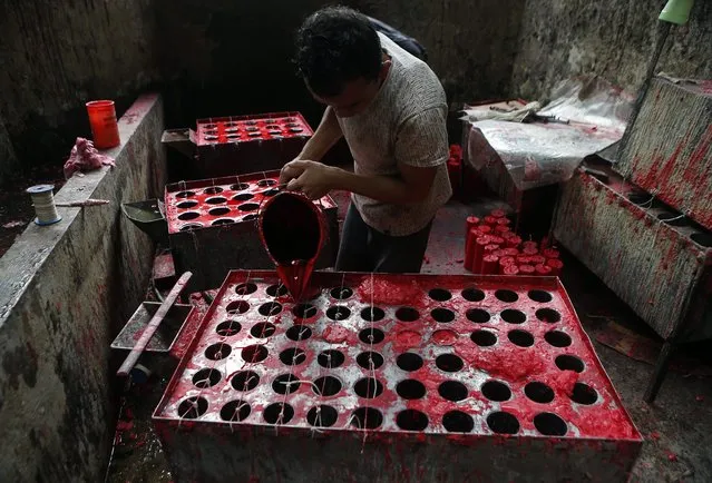 An Indonesian worker put liquid wax into a molding of candles at a traditional Chinese candle maker for the upcoming Lunar New Year in Bogor, Indonesia, 27 January  2015. (Photo by Adi Weda/EPA)