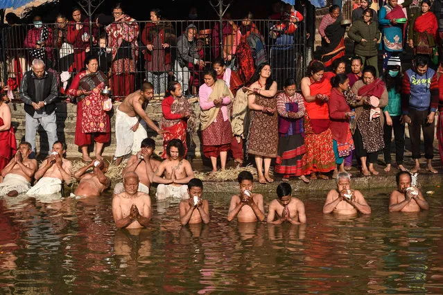 Hindu devotees take part in a bathing ritual during the month-long Swasthani festival at the Hanumante River in Bhaktapur on the outskirts of Kathmandu on February 08, 2021. (Photo by Prakash Mathema/AFP Photo) 