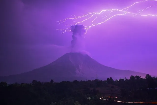 The long-time exposure photo taken on March 5, 2021 shows lightning striking near Mount Sinabung with white smoke being spewed in Karo, North Sumatra, Indonesia. (Photo by Sarianto Sembiring/Xinhua News Agency/Eyevine)