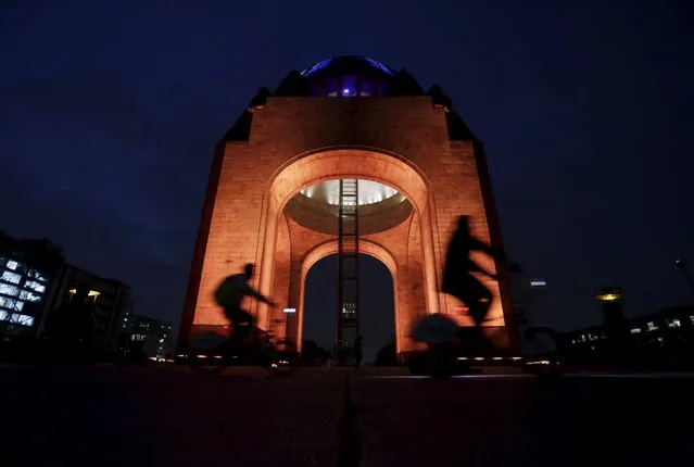 Cyclists ride past the illuminated Monument to the Revolution in Mexico City, November 23, 2015. (Photo by Daniel Becerril/Reuters)