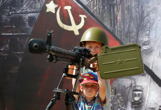 Children play with a Soviet-era machine gun during the International Army Games 2018, in Alabino outside Moscow, Russia, July 28, 2018. (Photo by Sergei Karpukhin/Reuters)