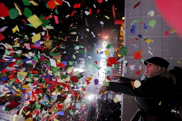 Revelers throw confetti from a balcony to celebrate during New Year festivities above Times Square in New York January 1, 2016. (Photo by Lucas Jackson/Reuters)