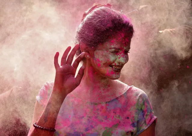 A woman daubed in colours reacts as colour powder is thrown towards her during Holi celebrations, amidst the spread of the coronavirus disease (COVID-19), in Chennai, India, March 29, 2021. (Photo by P. Ravikumar/Reuters)