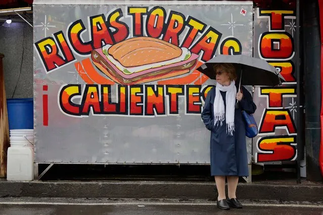 A woman holds an umbrella as she waits to cross the street on Tlahuac Avenue and Taxquena Avenue in Mexico City after it rained in the capital. This Thursday, on July 27, 2023, in Mexico City, the Secretariat for Integral Risk Management and Civil Protection, activated the yellow and orange alert in several municipalities after rains and strong winds were recorded during the afternoon of Thursday in the capital. (Photo by Gerardo Vieyra/NurPhoto/Rex Features/Shutterstock)