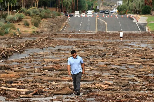 A worker from the Coachella Valley Water Department surveys the debris flow following heavy rains from Tropical Storm Hilary, at Thurderbird Country Club in Rancho Mirage, California, on August 21, 2023. Tropical Storm Hilary drenched Southern California with record rainfall, shutting down schools, roads and businesses before edging in on Nevada on August 21, 2023. California Governor Gavin Newsom had declared a state of emergency over much of the typically dry area, where flash flood warnings remained in effect until this morning. (Photo by David Swanson/AFP Photo)