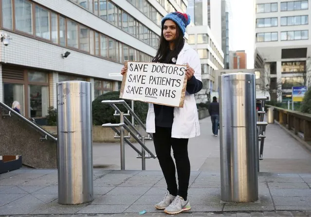 A doctor holds a placard during a strike outside St Thomas' hospital in central London, Britain January 12, 2016. English doctors staged their first strike in 40 years on Tuesday over government plans to reform pay and conditions for working anti-social hours, in a move health chiefs have warned could put patients' lives at risk. (Photo by Stefan Wermuth/Reuters)