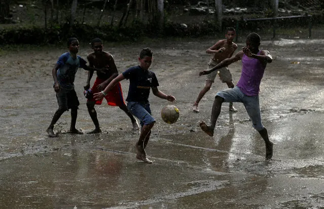 Children play soccer under the rain in Santiago de Cuba, Cuba, December 3, 2016. (Photo by Enrique de la Osa/Reuters)