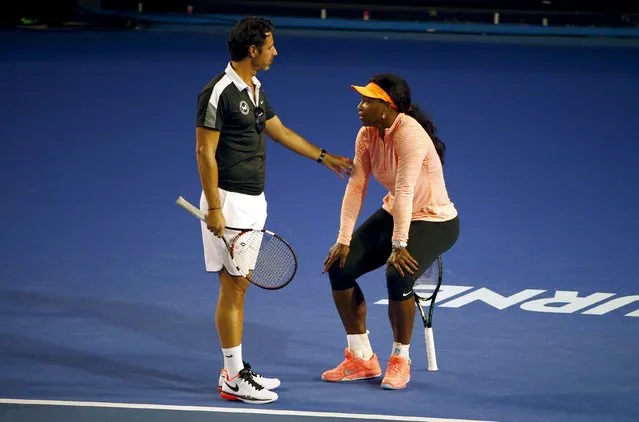 Serena Williams (R) of the U.S. sits on her racquet as she talks to her coach Patrick Mouratoglou during a practice session at Melbourne Park, Australia, January 14, 2016. The Australian Open tennis tournament starts January 18. (Photo by David Gray/Reuters)