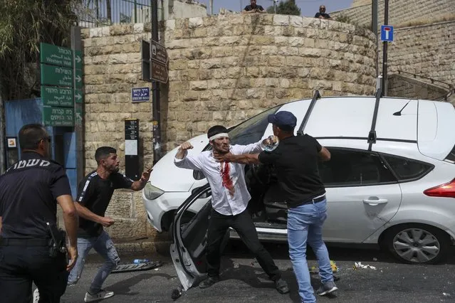 A Jewish driver, center, scuffles with Palestinians after he was attacked by Palestinian protesters near Jerusalem's Old City. Monday, May 10, 2021. (Photo by Ohad Zwigenberg/AP Photo)