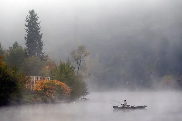 A fisherman sits in a boat on Vltava river during a foggy morning near Prague, Czech Republic, October 23, 2016. (Photo by David W. Cerny/Reuters)