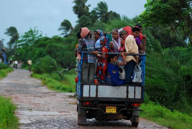 Indian evacuees travel in an auto rickshaw as they leave their village towards a safe place through heavy wind and rain in Sanabandha Village near Gopalpur, about 195 south from eastern city Bhubaneswar on October 12, 2013. Nearly half a million people have been evacuated from India's impoverished east coast ahead of a massive cyclone expected to make landfall on October 12 evening, disaster officials said. (Photo by Asit Kumar/AFP Photo)