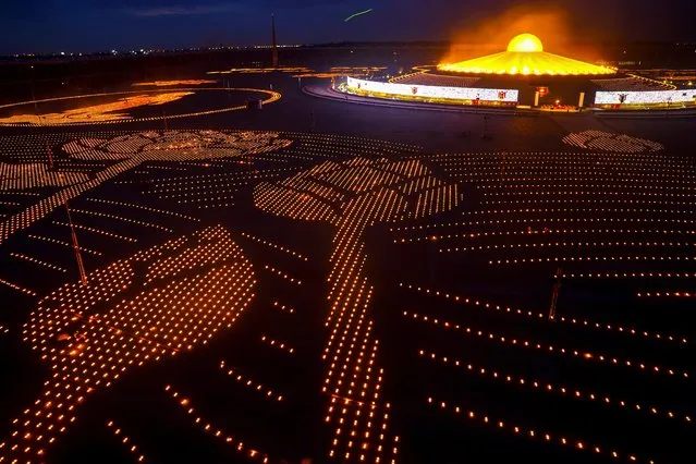 Candles are lit during Vesak Day, an annual celebration of Buddha's birth, enlightenment and death at the Dhammakaya temple amid the coronavirus disease (COVID-19) pandemic in Pathum Thani province, Thailand, May 26, 2021. (Photo by Athit Perawongmetha/Reuters)