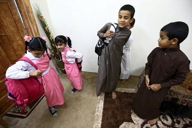 Saudi children of al-Fefi family prepare themselves before they go to their school through Fifa Mountain, in Jazan, south of Saudi Arabia, December 15, 2016. (Photo by Mohamed Al Hwaity/Reuters)