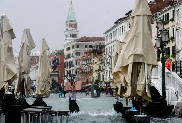A man carries a table in the flooded Riva degli Schiavoni during a high- water (Acqua Alta) alert in Venice on October 29, 2018. The flooding, caused by a convergence of high tides and a strong Sirocco wind, reached around 150 centimetres. (Photo by Miguel Medina/AFP Photo)