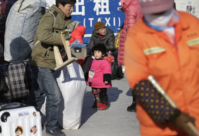 Two-year-old Xuanxuan stands among passengers as she and her parents wait for their train to their hometown Nantong of Jiangsu province at Beijing Railway station, in Beijing, China, January 25, 2016. (Photo by Jason Lee/Reuters)