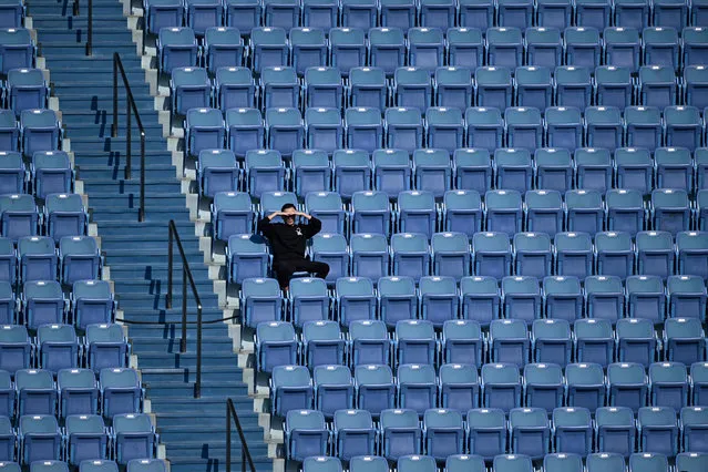 A spectator watches the men's singles match between Chile’s Nicolas Jarry and Argentina’s Diego Schwartzman at the Shanghai Masters tennis tournament on October 11, 2023. (Photo by Wang Zhao/AFP Photo)