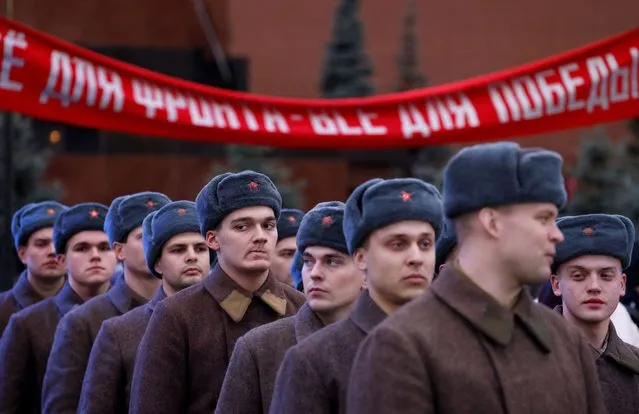 Participants line up during an exhibition marking the anniversary of a historical parade in 1941, when Soviet soldiers marched towards the front lines in the course of World War Two, in Red Square in Moscow, Russia on November 7, 2023. A slogan on a banner reads: “Everything for the front line, everything for the victory”. (Photo by Maxim Shemetov/Reuters)