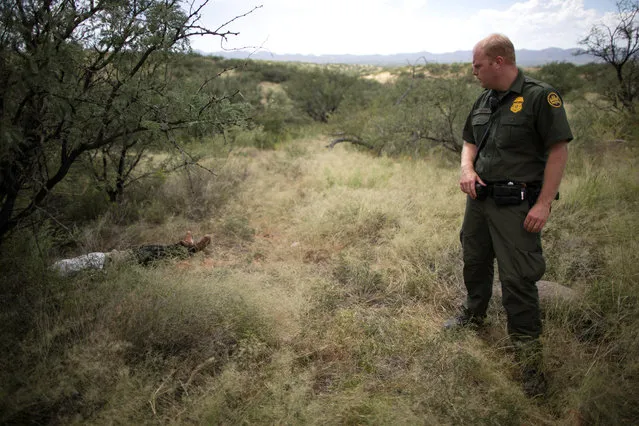 Border Patrol Agent Jacob Stukenberg looks at Guatemalan migrant Misael Paiz, 25, who died in the Sonoran Desert after traveling over 2,000 miles to cross the U.S.-Mexico border, on the Buenos Aires National Wildlife Refuge in Pima County, Arizona, September 10, 2018. (Photo by Lucy Nicholson/Reuters)