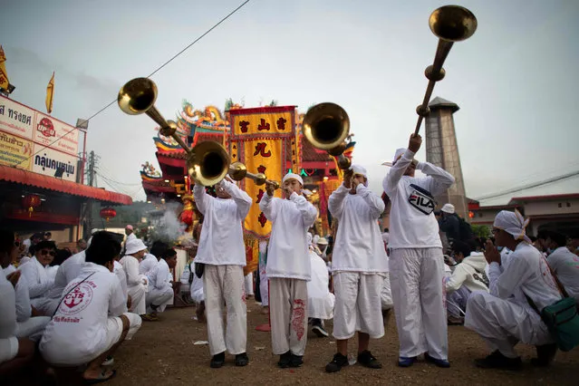 Devotees of the Loem Hu Thai Su shrine parade during the annual Vegetarian Festival in Phuket on October 12, 2018. The festival begins on the first evening of the ninth lunar month and lasts for nine days, with many religious devotees slashing themselves with swords, piercing their cheeks with sharp objects and committing other painful acts to purify themselves, taking on the sins of the community. (Photo by Jewel Samad/AFP Photo)