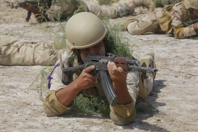 A member from the Iraqi security forces carries his weapon during military training in Jurf al-Sakhar, Iraq April 9, 2015. (Photo by Alaa Al-Marjani/Reuters)