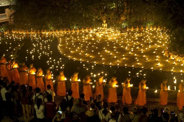 Buddhist monks hold candles during Makha Bucha day at Wat Pan Tao in Chiang Mai, Thailand, February 22, 2016. (Photo by Athit Perawongmetha/Reuters)