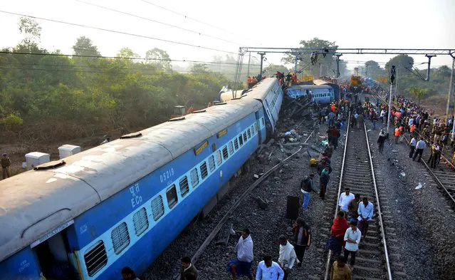 Rescue workers search for victims at the site of the derailment of the Jagdalpur-Bhubaneswar express train near Kuneru station in southern Andhra Pradesh state on January 22, 2017. Rescuers battled to pull survivors from the wreckage of a train crash which killed 32 passengers in southern India, the latest in a series of disasters on the country's creaking rail network. (Photo by AFP Photo/Stringer)