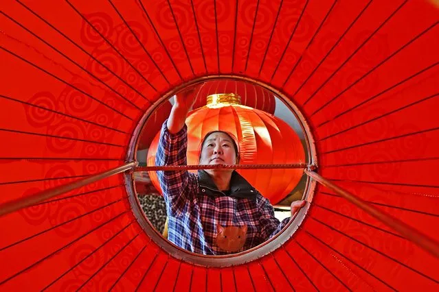 A worker produces lanterns at a factory in Yantai, in eastern China's Shandong province on January 8, 2024. (Photo by AFP Photo/China Stringer Network)