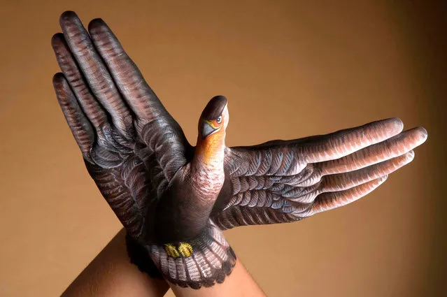 Models poses with their arm after it was painted by body artist Guido Daniele