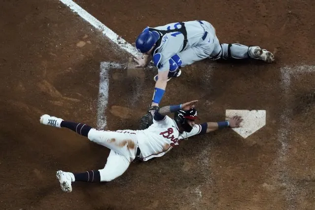 Los Angeles Dodgers catcher Will Smith can not make the tag on Atlanta Braves Ozzie Albies scores on a single by Austin Riley in the eighth inning in Game 2 of baseball’s National League Championship Series Sunday, October 17, 2021, in Atlanta. (Photo by John Bazemore/AP Photo)
