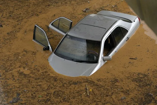 A car is submerged in flood water at a highway flooded by the rains, in Beirut, Lebanon, Saturday, December 23, 2023. A rainstorm has paralysed parts of Lebanon's cities, turning streets to small rivers, stranding motorists inside their vehicles and damaging homes in some areas. (Photo by Hussein Malla/AP Photo)
