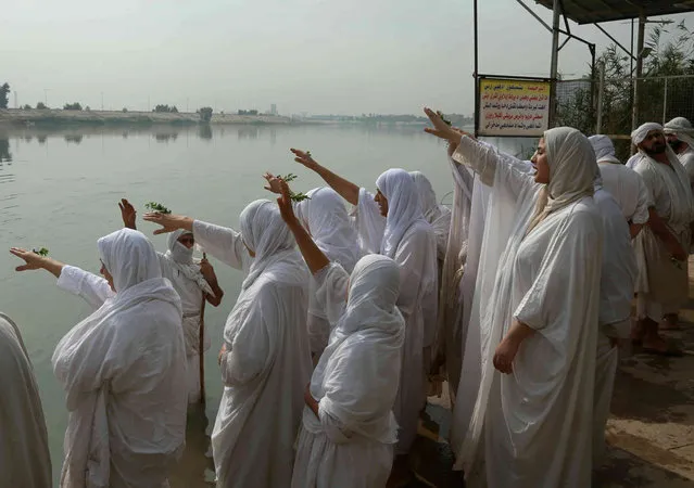 Members of Iraq's Sabean-Mandaean community take part in a ritual during the Prosperity Day celebration in the Tigris River, in central Baghdad, Iraq, Monday, November 1, 2021. Mandaeism follows the teachings of John the Baptist, a saint in both the Christian and Islamic traditions, and its rites revolve around water. (Photo by Hadi Mizban/AP Photo)