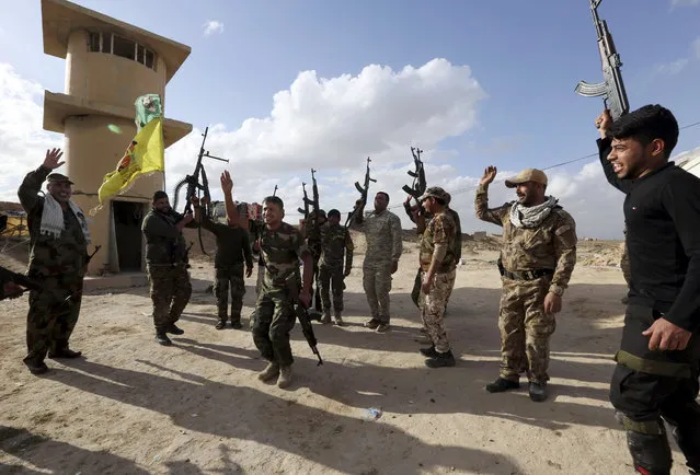 In this Sunday, Feb. 7, 2016 photo, Shiite fighters chant slogans against the Islamic State group at the frontline in Tikrit, Iraq, 80 miles (130 kilometers) north of Baghdad. Iraq's Shiite militias, mobilized in 2014 to fight the Islamic State group, are now showing they have no intention to stand down once the fight against the Sunni extremists is over. (Photo by Hadi Mizban/AP Photo)