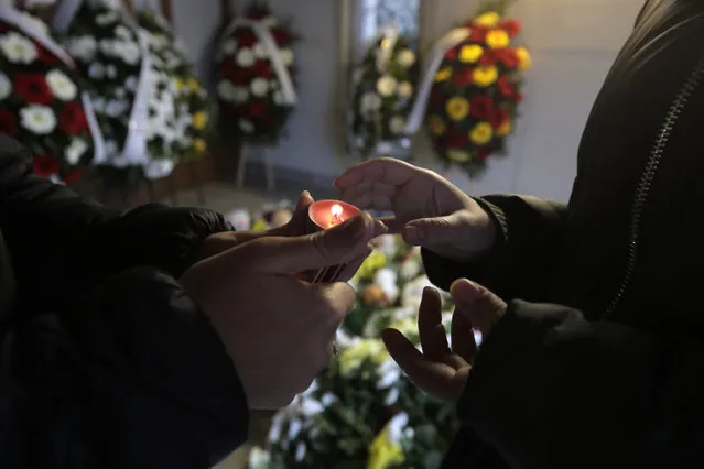 People light candles and lay flowers at the North Macedonian embassy in Sofia, Wednesday, November 24, 2021, as they pay their respects to the victims of a bus crash. Bulgaria and North Macedonia began periods of national mourning on Wednesday, a day after a bus traveling through Bulgaria carrying tourists to neighboring North Macedonia crashed and caught fire, killing 45 people. (Photo by Valentina Petrova/AP Photo)