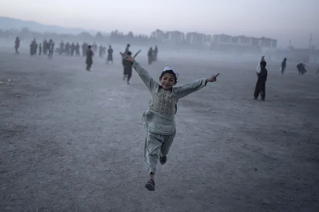 A young boy celebrates as he plays cricket with his friends in Chaman-e-Hozori park, Kabul, Afghanistan, Friday, November 19 , 2021. (Photo by Petros Giannakouris/AP Photo)