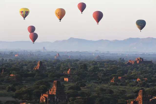 Hot air balloons fly over Myanmar's ancient temples just before the sunrise on New Year's Day in Bagan, Nyaung U district, central Myanmar, Monday, January 1, 2024. (Photo by Aung Shine Oo/AP Photo)
